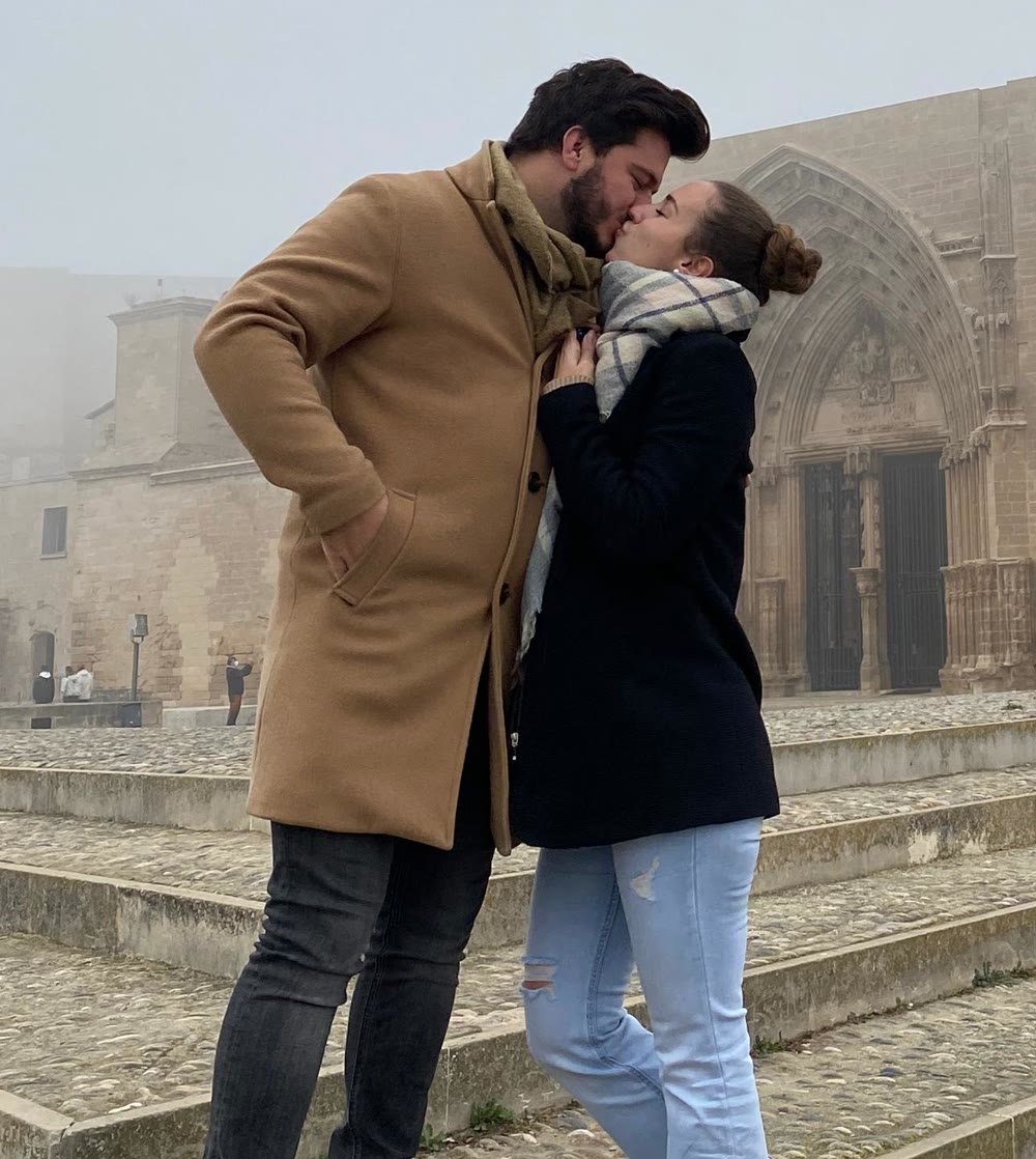 Raquel y Samuel besándose en la escalinata de una catedral, entre la niebla